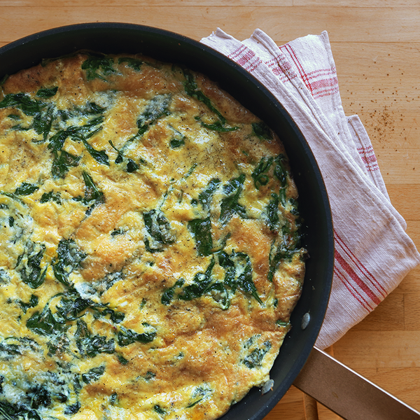 Spinat-Frittata in einer Pfanne direkt aus dem Ofen mit Parmesan überbacken